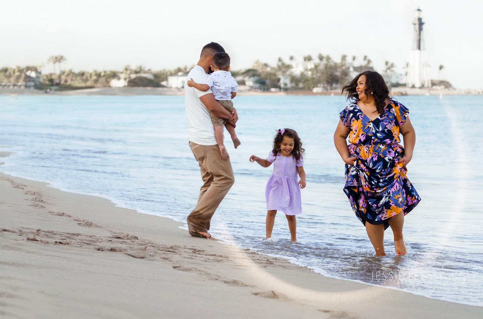 Family photographer pompano beach lighthouse point jumping waves at beach jessie lee photography